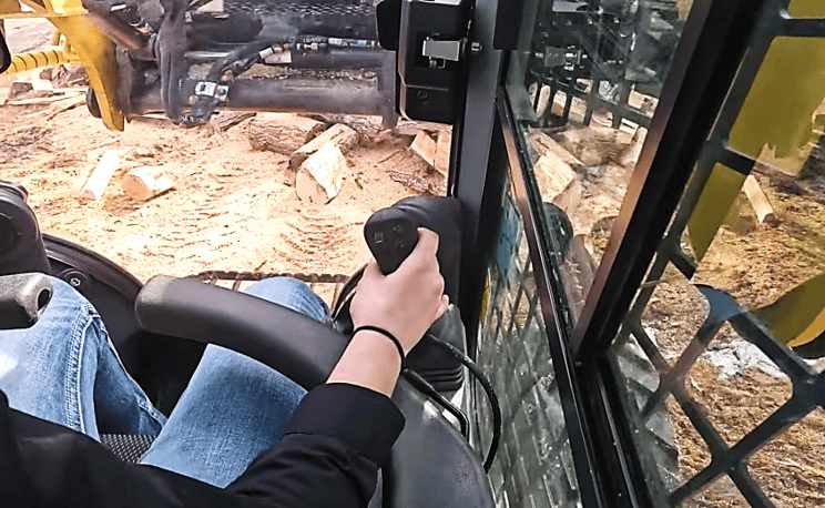 A person operates the Halverson HWP-160 from inside the cab of their host machine.