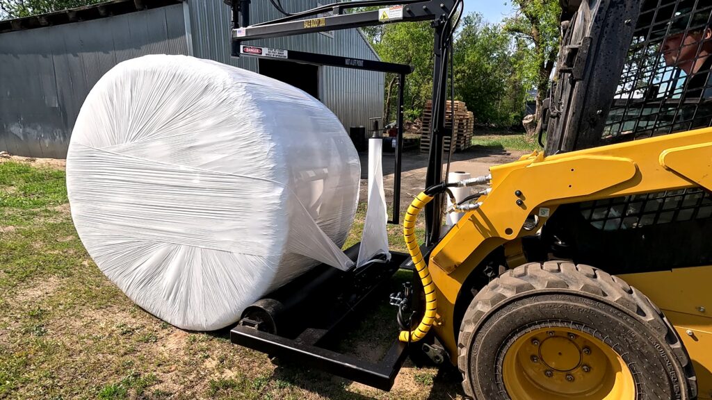 The Halverson HWP-Bale Wrapper lifts a wrapped bale.
