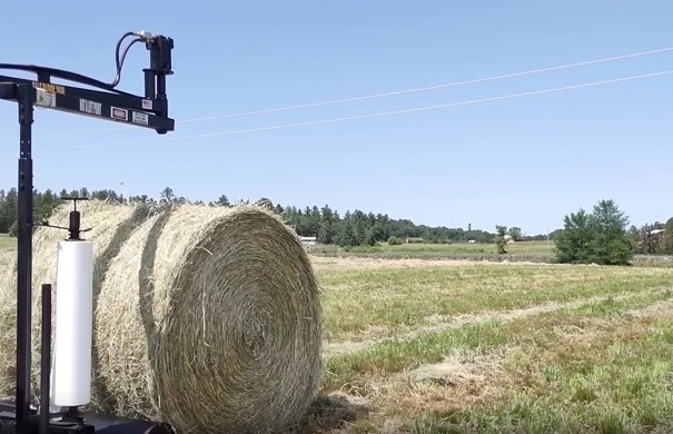 The Halverson HWP-Bale Wrapper wrapping a round hay bale.